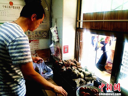 圖為凌君道正在將粽子裝袋進行售賣?！「呖档?攝